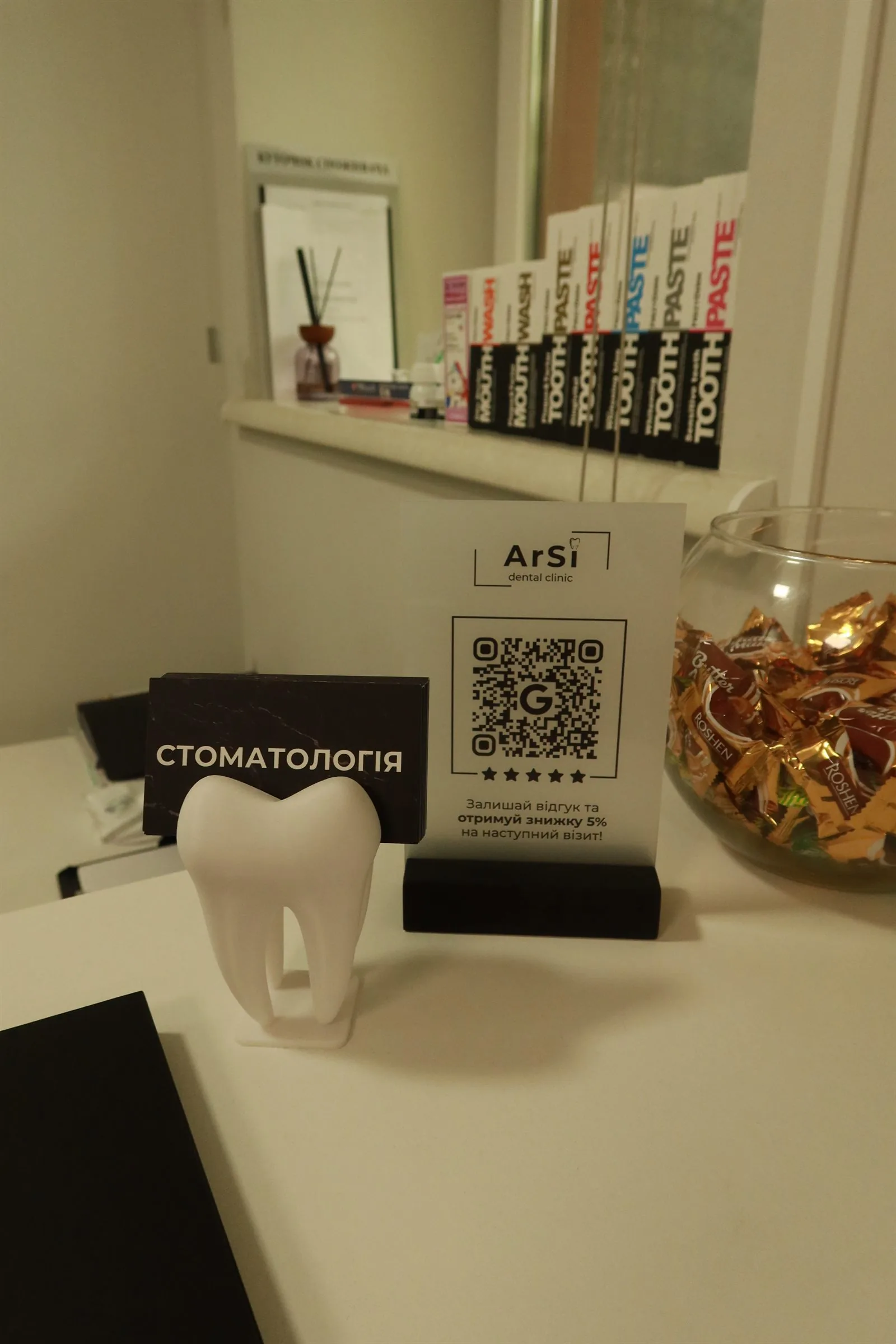 Деталі ресепшену ArSi Dental з QR та брендом